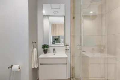 a white bathroom with a sink and a shower at WanderHaus Haven, Ellipse in Midrand