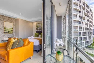 a hotel room with a bed and a balcony at WanderHaus Haven, Ellipse in Midrand