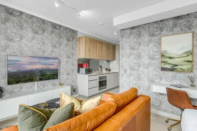 a living room with a couch and a kitchen at WanderHaus Haven, Ellipse in Midrand