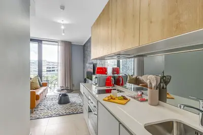 a kitchen with a sink and a couch in a room at WanderHaus Haven, Ellipse in Midrand