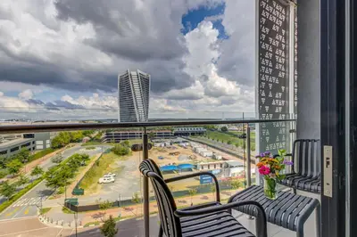 a balcony with two chairs and a view of a city at Serene Spaces, Ellipse in Midrand
