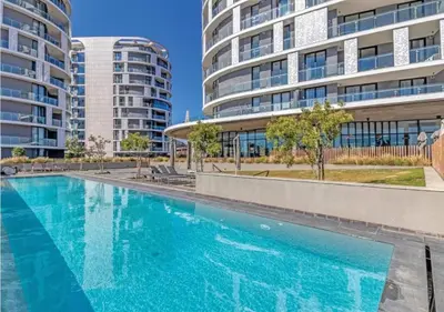 a swimming pool in front of two tall buildings at Serene Spaces, Ellipse in Midrand