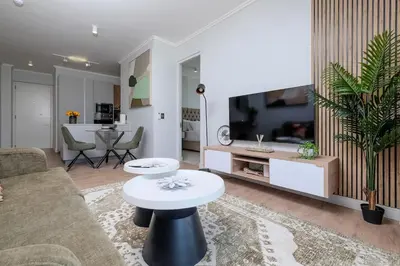 a living room with a couch and a tv at Ellips Smartz Apartment in Midrand