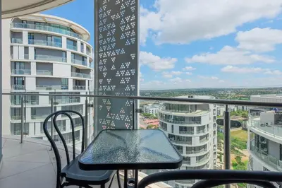 a balcony with a table and chair on a building at Ellips Smartz Apartment in Midrand
