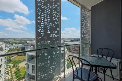 a balcony with a table and chairs in a building at Ellips Smartz Apartment in Midrand