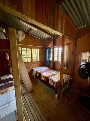 a bedroom with a bed in a wooden cabin at Backpackers at Kanaan in Hazyview