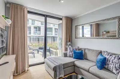 a living room with a couch and a large window at The Quanta, Ellipse, Watefall in Midrand