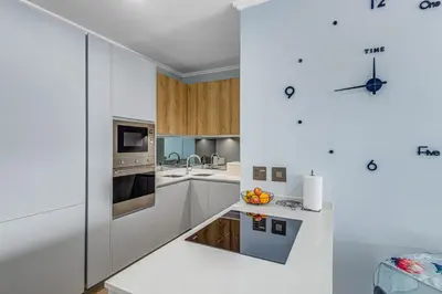 a kitchen with white cabinets and a stove top oven at The Quanta, Ellipse, Watefall in Midrand