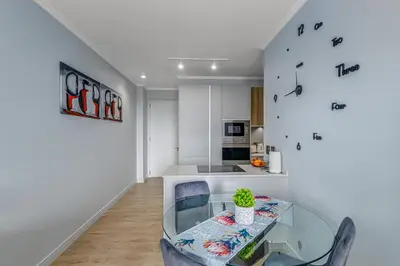 a dining room with a glass table and a kitchen at The Quanta, Ellipse, Watefall in Midrand