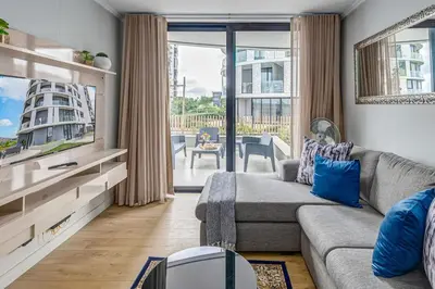 a living room with a couch and a tv at The Quanta, Ellipse, Watefall in Midrand
