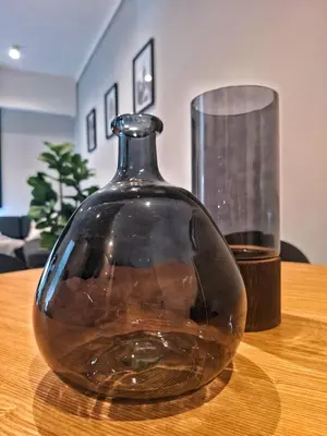 a glass vase sitting on top of a wooden table at Menlyn Maine Apartment - 738 at Maine in Pretoria