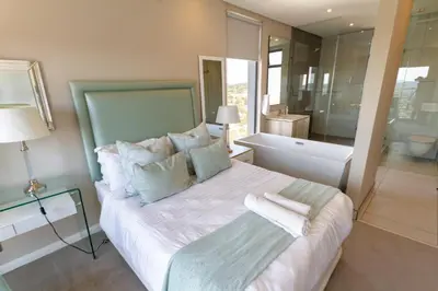 a bedroom with a large bed and a bath room at #AlimamaSpaces Koki's Place Menlyn in Pretoria