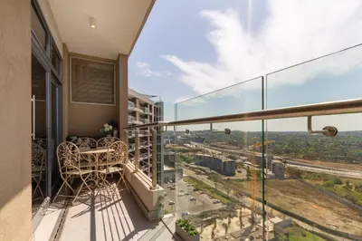 a balcony with a view of a city at #AlimamaSpaces Koki's Place Menlyn in Pretoria