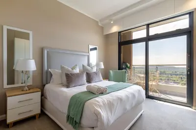 a bedroom with a large bed with a large window at #AlimamaSpaces Koki's Place Menlyn in Pretoria