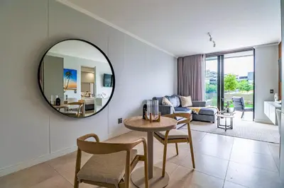 a living room with a table and a mirror at Waterfall Ellipse-4014 Patimo Opulent Apartment in Midrand