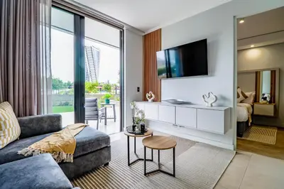 a living room with a couch and a tv at Waterfall Ellipse-4014 Patimo Opulent Apartment in Midrand