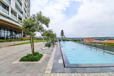 a swimming pool on the side of a building at Waterfall Ellipse-4014 Patimo Opulent Apartment in Midrand