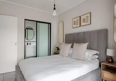 a bedroom with a large white bed with white pillows at Morden Waterfall Escape in Midrand