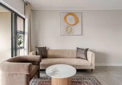 a living room with a couch and a table at Morden Waterfall Escape in Midrand
