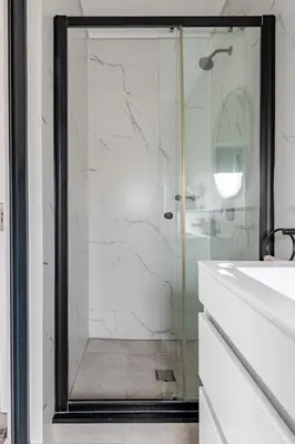 a shower with a glass door in a bathroom at Morden Waterfall Escape in Midrand