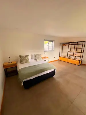 a bedroom with a large bed and a window at Boūs in Graskop