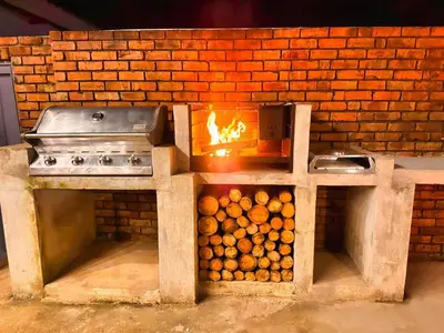 a brick oven with a stove and a pile of logs at Boūs in Graskop