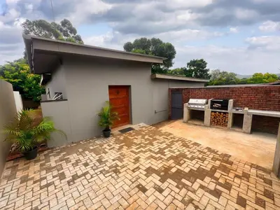 a brick house with a patio in front of it at Boūs in Graskop