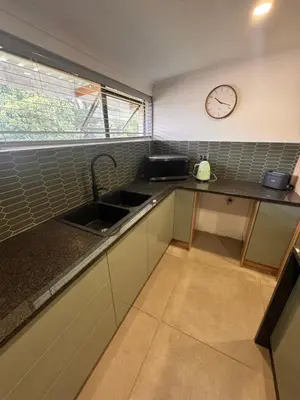 a kitchen with a sink and a clock on the wall at Boūs in Graskop