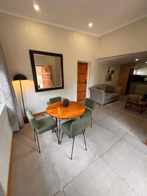 a dining room with a wooden table and chairs at Boūs in Graskop