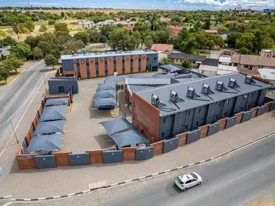 an overhead view of a building with a car on a road at De Stroom Studio Apartments in Secunda
