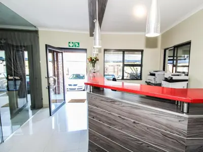 a red counter in the lobby of a building at De Stroom Studio Apartments in Secunda