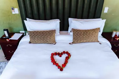 a heart shaped pillow sitting on a bed at Atimangeni Bush Guest House in Dwarsloop