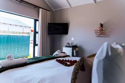 a bedroom with a bed with a view of the ocean at Atimangeni Bush Guest House in Dwarsloop