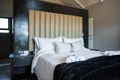 a large white bed with two stuffed animals on it at Atimangeni Bush Guest House in Dwarsloop