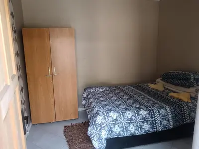a bedroom with a bed and a wooden cabinet at 12 Bologna B&B in Evander