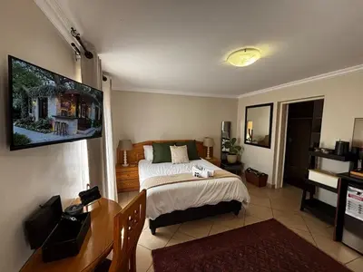a bedroom with a bed and a flat screen tv at Olivestay at Olympus - Studio Apartment in Pretoria