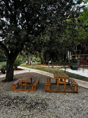 two picnic tables in a park with a playground at Olivestay at Olympus - Studio Apartment in Pretoria