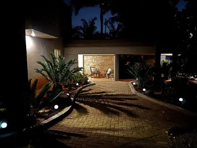 a courtyard with plants and a building at night at Olivestay at Olympus - Studio Apartment in Pretoria