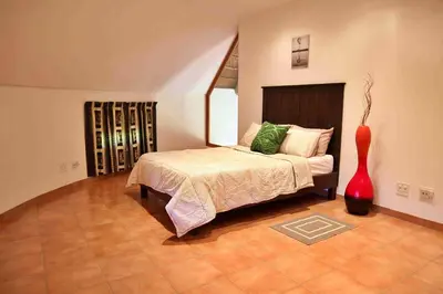a bedroom with a bed and a red vase at Madlabeezy in Kempton Park