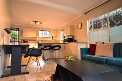 a kitchen and living room with a couch and a table at Unusual stay in Pretoria