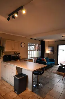 a kitchen and living room with a table and a couch at Unusual stay in Pretoria