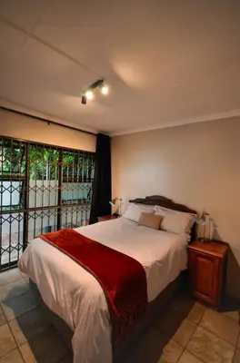 a bedroom with a bed and a large window at Unusual stay in Pretoria
