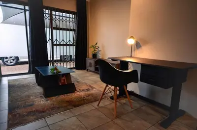 a room with a desk and a chair and a table at Unusual stay in Pretoria