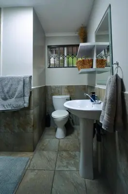 a bathroom with a white sink and a toilet at Unusual stay in Pretoria