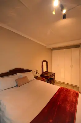 a bedroom with a large bed and a desk at Unusual stay in Pretoria