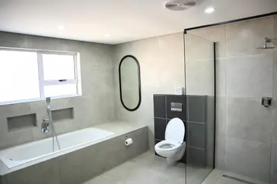 a bathroom with a tub and a toilet and a shower at 78onJean in Centurion