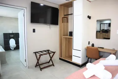 a room with a bed and a tv on a wall at 78onJean in Centurion
