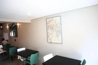 a room with tables and chairs and a picture on the wall at 78onJean in Centurion
