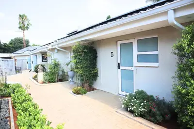 a white house with a door with the number six at 78onJean in Centurion