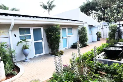 a small white house with a garden in front of it at 78onJean in Centurion